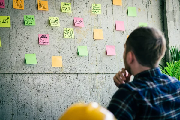 Indietro di ingegnere seduto in ufficio e guardare colorato appiccicoso m — Foto Stock