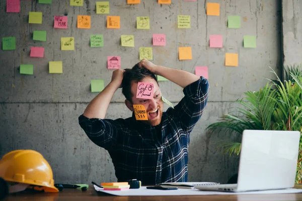 Stressad man med meddelande på klisterlappar över sitt ansikte i offic — Stockfoto