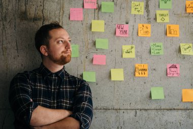 Mutlu bir adam kol yapışkan notlar grafik ile çimento duvara geçti. E