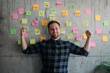 Mutlu bir adam onun yapışkan notlar grafik çimento duvar üzerinde mevcut. Girişimcilik