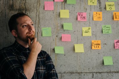 Mutlu bir adam kol yapışkan notlar grafik ile çimento duvara geçti. E