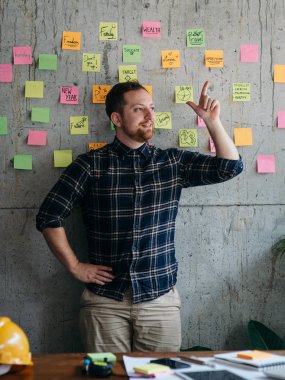 Mutlu mühendis adam çimento duvarda onun yapışkan notlar grafik mevcut