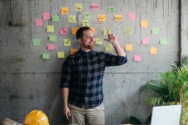 Mutlu mühendis adam çimento duvarda onun yapışkan notlar grafik mevcut