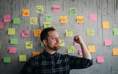 Mutlu mühendis adam çimento duvarda onun yapışkan notlar grafik mevcut