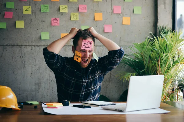 Стрессовый человек с сообщением на липких записках на лице на официальном языке — стоковое фото