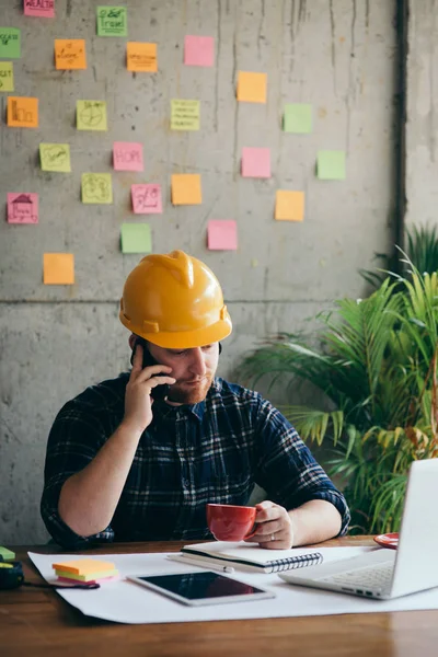 Ingenieur praten met telefoon en het drinken van koffie in Office, kleur — Stockfoto