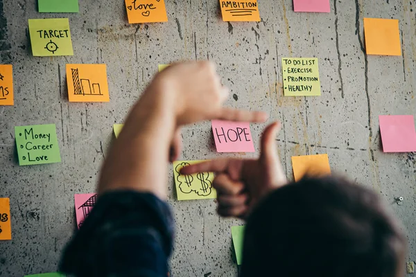 Back of entrepreneur sitting in office and look at colorful stic — Stock Photo, Image