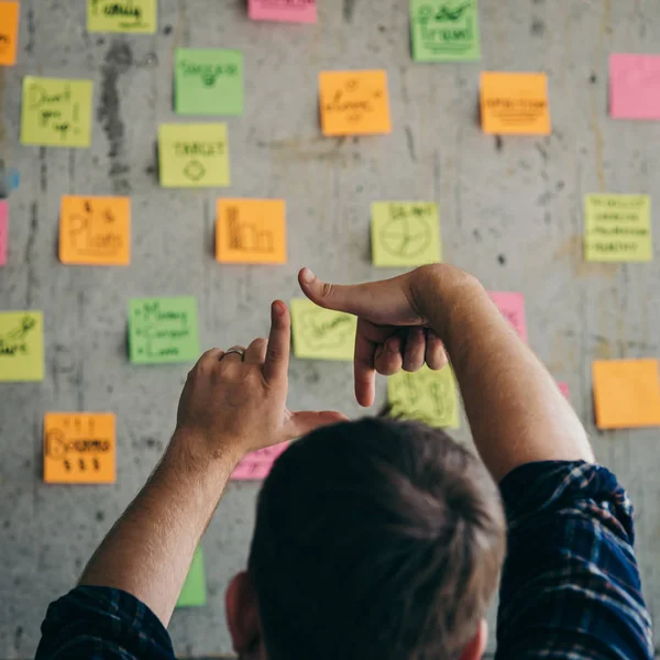 Back of entrepreneur sitting in office and look at colorful stic — Stock Photo, Image