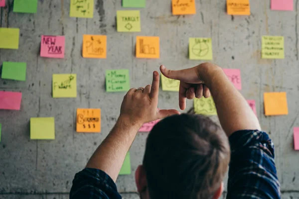 Back of entrepreneur sitting in office and look at colorful stic — Stock Photo, Image