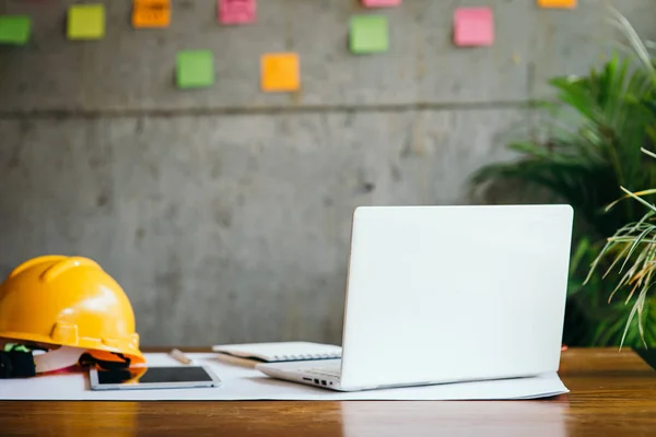 Ingenieur helm, witte laptop op tafel en kleurrijke Sticky Notes — Stockfoto