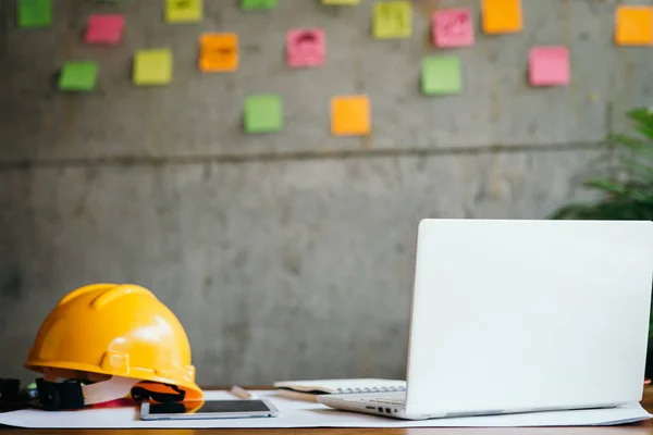 Casco de ingeniero, portátil blanco en la mesa y notas adhesivas de colores —  Fotos de Stock