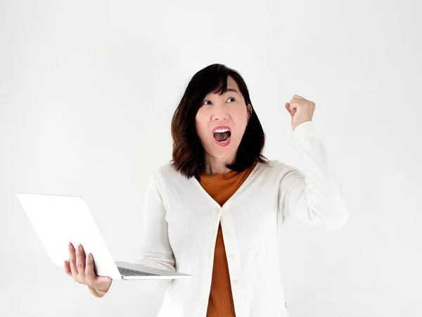 Happy Asian woman using laptop against the wall and raising her — Stock Photo, Image