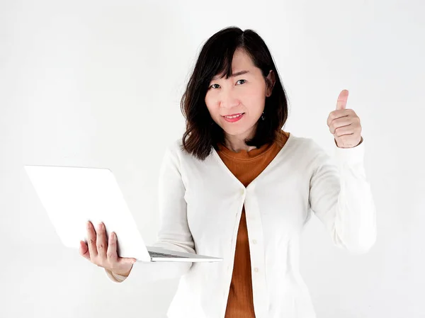 Thumbs up happy Asian woman using laptop against the wall, lifes — Stock Photo, Image