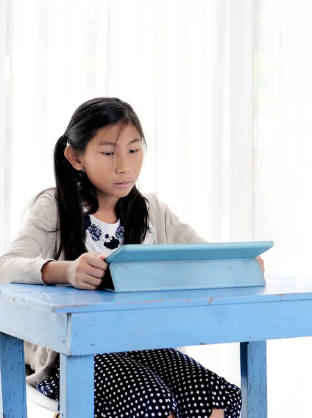 Ευτυχισμένο κορίτσι της Ασίας χρησιμοποιώντας ψηφιακό δισκίο στο μπλε τραπέζι, lifestyle c — Φωτογραφία Αρχείου