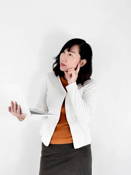 Thoughtful happy Asian woman using laptop against the wall, life — Stock Photo, Image