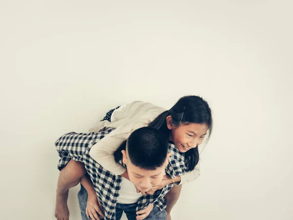 Happy Asian pretty girl enjoying riding on her brother piggyback — Stock Photo, Image