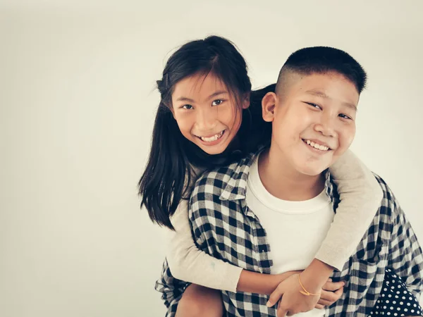 Feliz asiático bonita chica disfrutando a caballo en su hermano piggyback — Foto de Stock