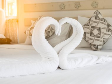 Kalp aşk işareti ile yatakta kuğu havlu.