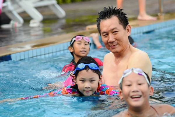 Asian father teaching his daughter to swim, lifestyle concept. — Stock Photo, Image