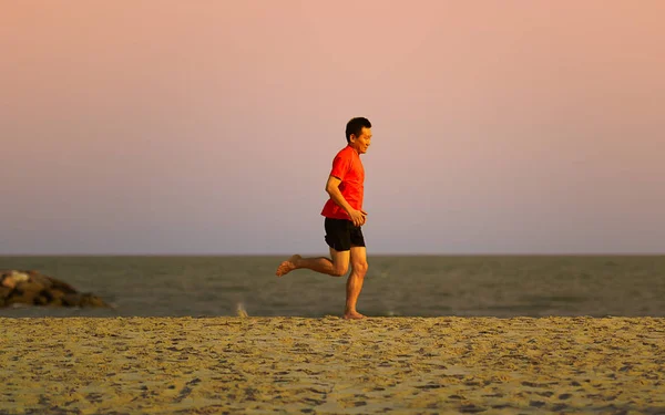 Motion blur Homem asiático correndo na praia à noite, estilo de vida — Fotografia de Stock