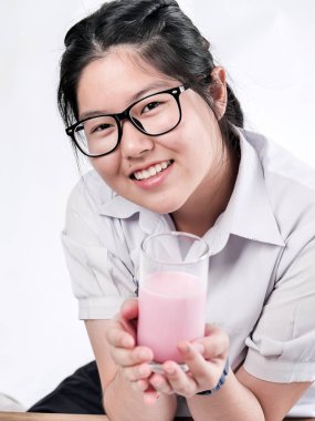 Cam çilek süt tutan üniforma mutlu Asyalı öğrenci 