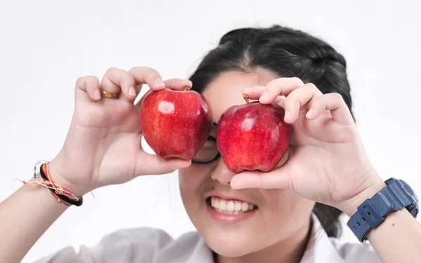 Happy schoolgirl hiding her eyes with red apple, lifestyle conce — Stock Photo, Image