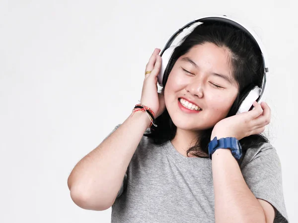 Heureux asiatique adolescent fille en utilisant casque et écouter de la musique . — Photo