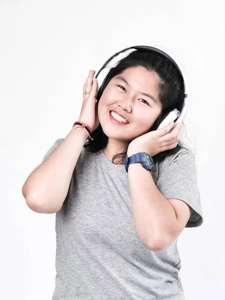 Счастливая азиатская девочка-подросток использует наушники и слушает музыку . — стоковое фото