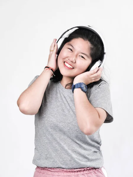 Счастливая азиатская девочка-подросток использует наушники и слушает музыку . — стоковое фото