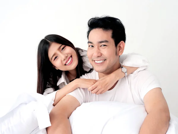 Glückliche asiatische Paar auf dem Bett zu Hause, Lifestyle-Konzept. — Stockfoto