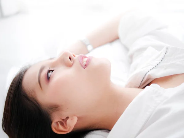 Mulher asiática feliz deitada na cama, fechada . — Fotografia de Stock