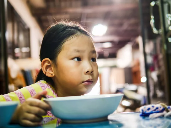 かわいいアジアの女の子は自宅で朝食のためにチャーハンを食べる. — ストック写真