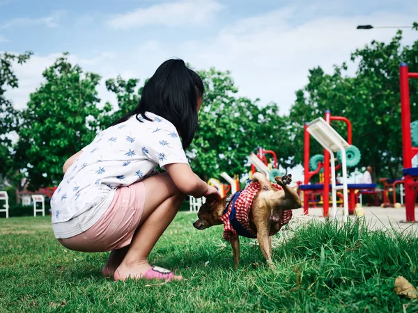 快乐的亚洲女孩有乐趣与她的狗在公园户外. — 图库照片