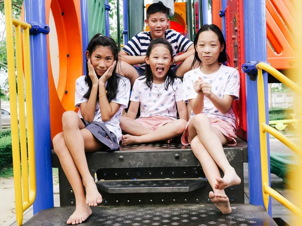 Szczęśliwy Asian dzieci siedzący na plac zabaw razem w The Park bas — Zdjęcie stockowe