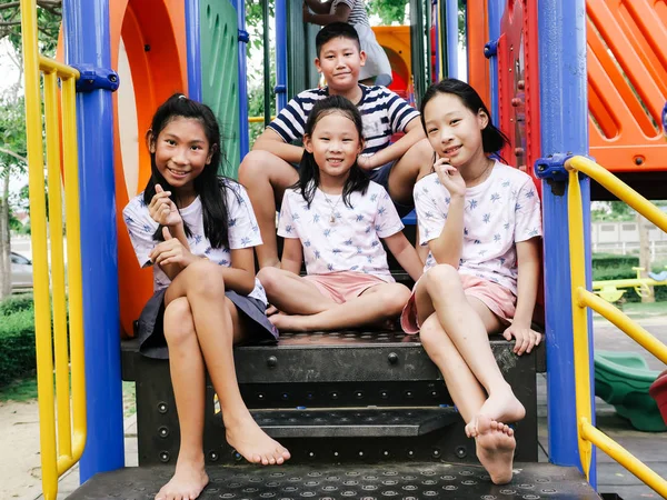 Mutlu Asyalı çocuklar parkta birlikte oyun başında oturan outd — Stok fotoğraf