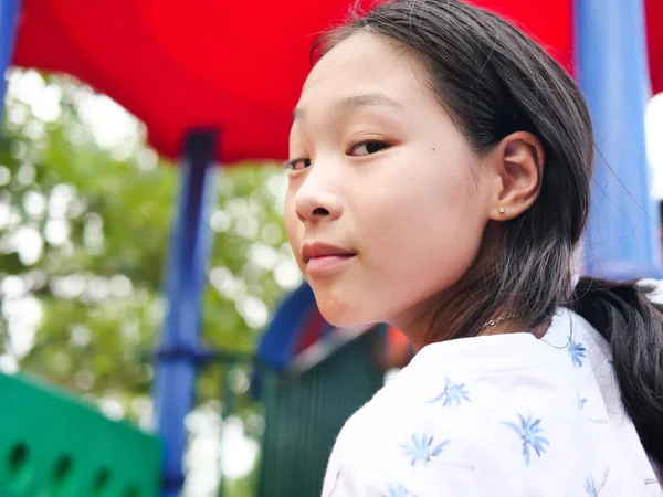 Asiatisches Mädchen spielt auf Spielplatz, Lifestyle-Konzept. — Stockfoto