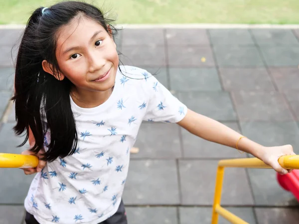 Asiatisches Mädchen spielt auf Spielplatz, Lifestyle-Konzept. — Stockfoto