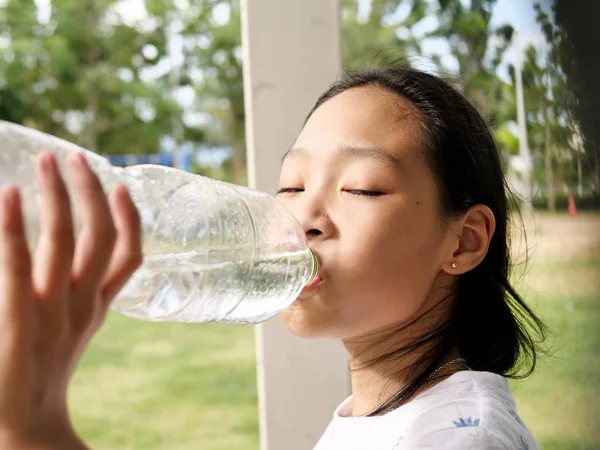 Asyalı kız açık su bir şişe içme.