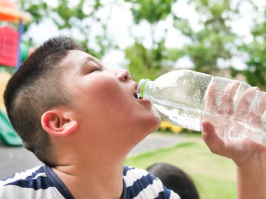 Yakın Asya çocuk plastik şişeden su içiyor 
