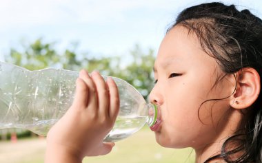 Asyalı kız açık su bir şişe içme.