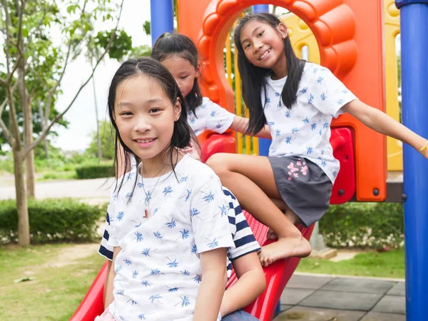 Mutlu Asyalı çocuklar parkta birlikte oyun başında oturan outd