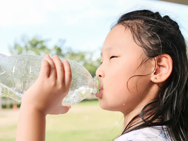 Asian girl drinking a bottle of water outdoor. — Stock Photo, Image