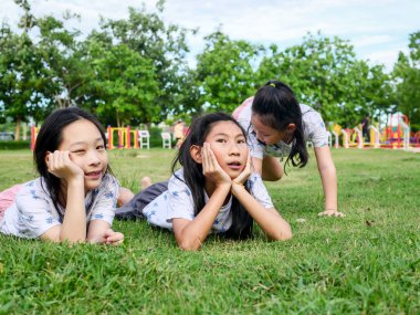 Mutlu Asyalı kızlar yeşil çimenler üzerinde birlikte açık yatıyordu, ben