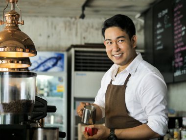 Kafede, yaşam kavramı çalışan mutlu Asya barista adam.