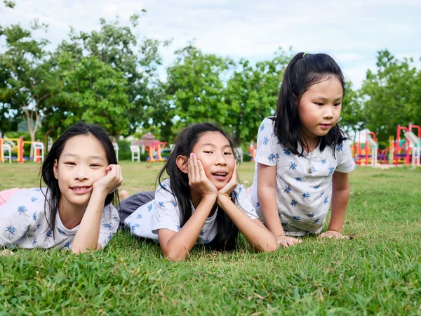 Felice ragazze asiatiche sdraiate su erba verde all'aperto insieme, l — Foto Stock