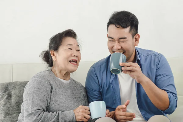 Asijská matka a její syn mluví a popíjejí doma, životní styl — Stock fotografie
