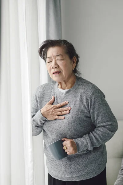 Asian senior woman have a heart attack at home, lifestyle concep