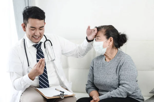 アジアの医師は オフィスで彼の患者の老婆をチェック — ストック写真