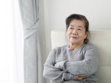 Mutlu Asya yaşlı kadın evde kanepede rahatlatıcı, yaşam tarzı con