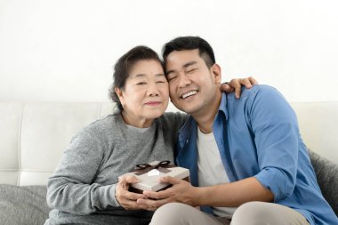 Anneler Günü c için annesine hediye kutusu veren Mutlu Asyalı adam